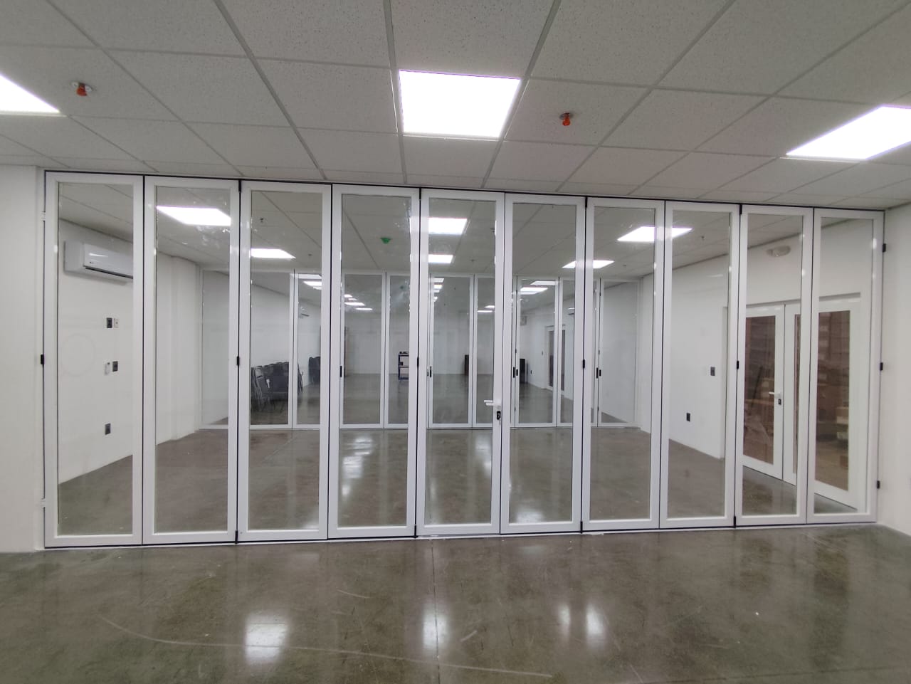 Sistema plegable de aluminio de gran formato instalado en un espacio amplio
